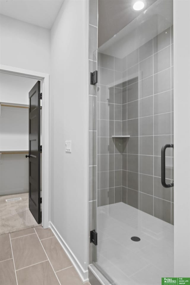 bathroom with tile patterned floors and a shower stall