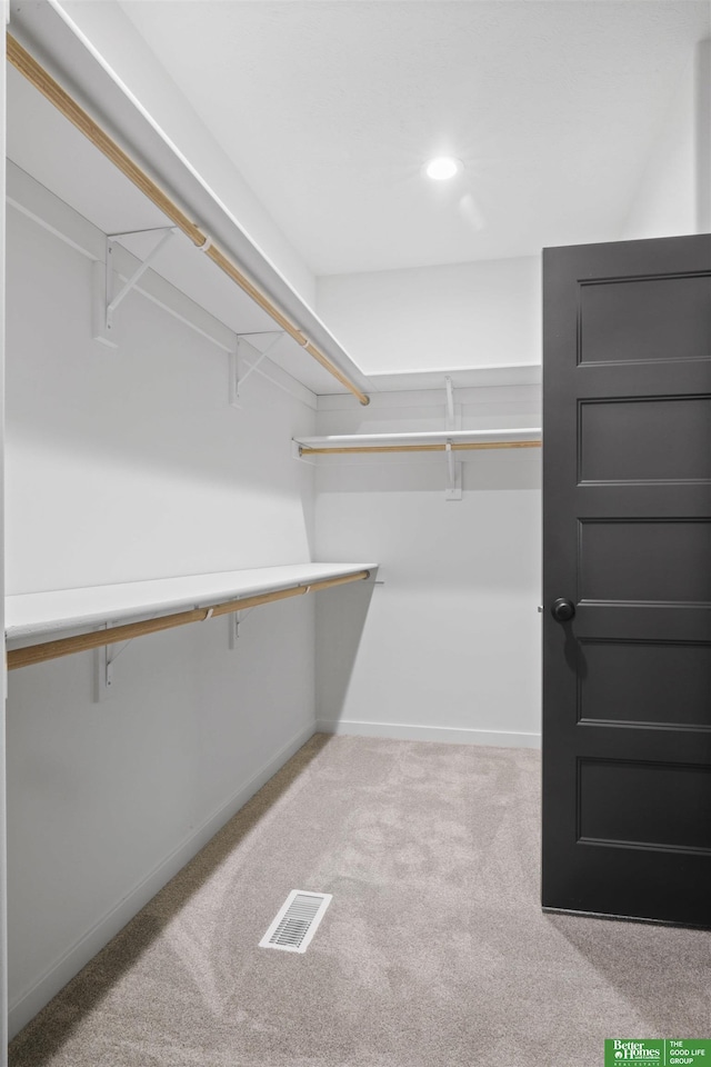 walk in closet featuring visible vents and light colored carpet