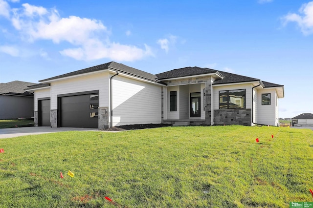prairie-style home with an attached garage, driveway, and a front yard