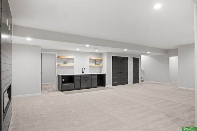 unfurnished living room featuring a sink, recessed lighting, and light carpet
