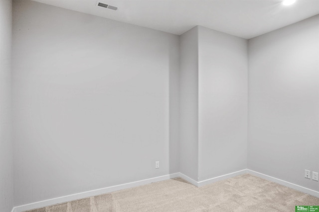 spare room with light carpet, visible vents, and baseboards