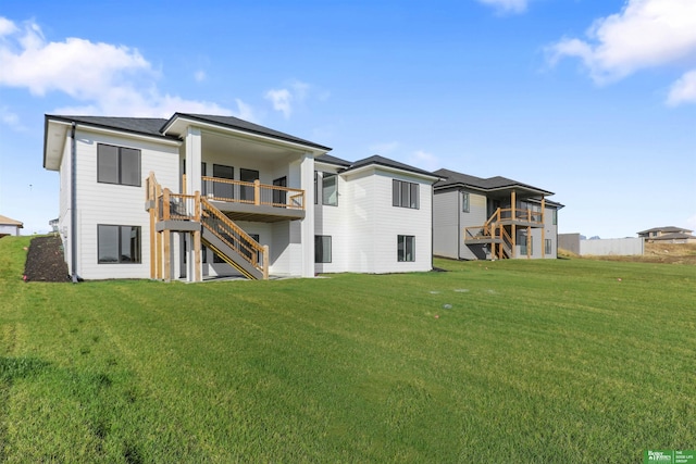 rear view of property featuring a lawn and stairs