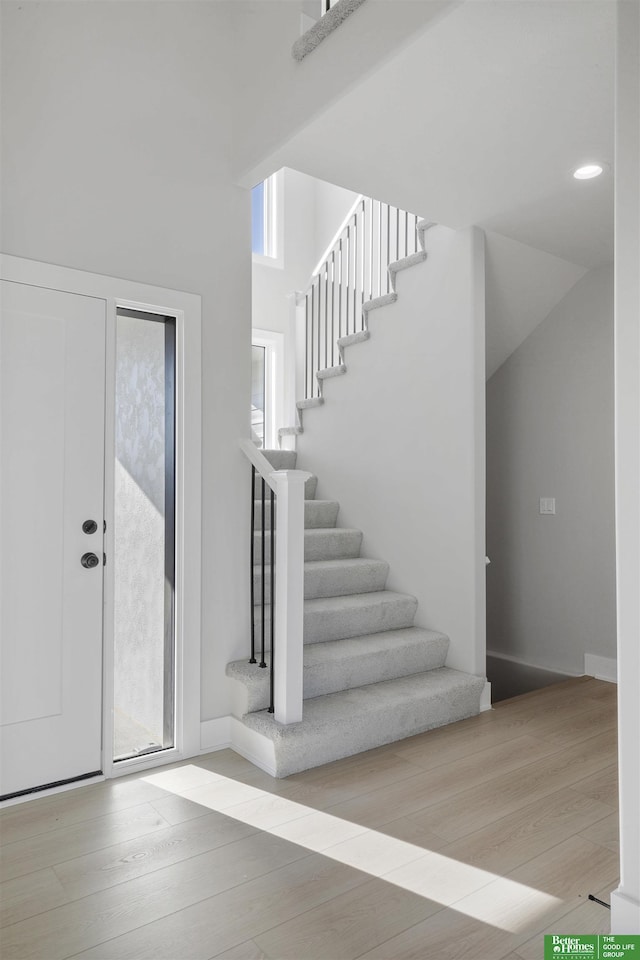 entryway with wood finished floors and stairs