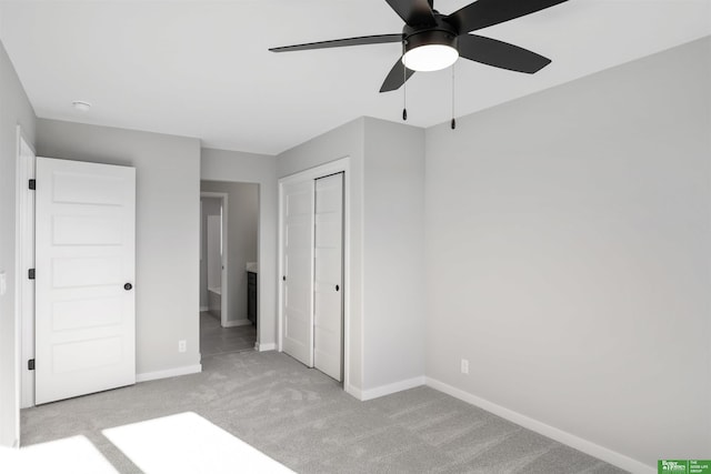 unfurnished bedroom with a closet, carpet, baseboards, and a ceiling fan