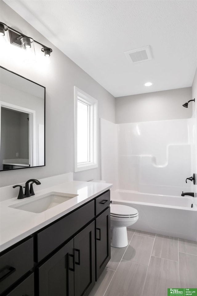 bathroom with toilet, vanity, tub / shower combination, and visible vents