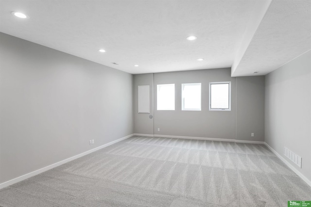 spare room featuring recessed lighting, visible vents, light colored carpet, and baseboards