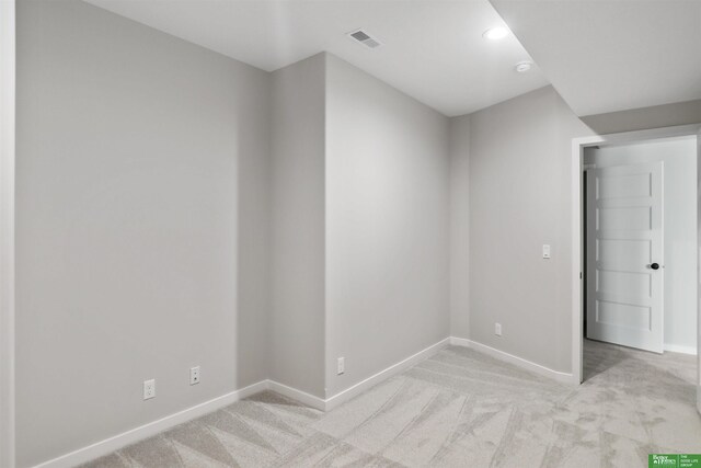 empty room featuring light carpet, recessed lighting, visible vents, and baseboards
