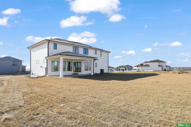 rear view of house featuring a lawn