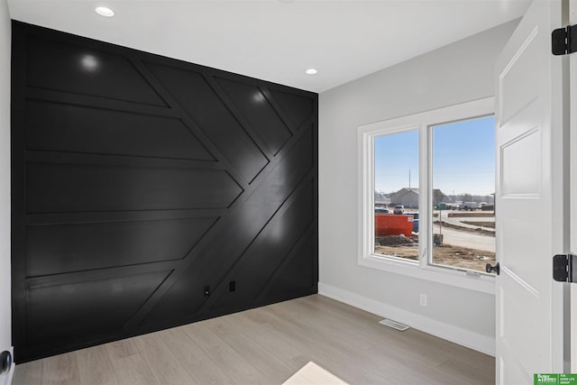 unfurnished room featuring light wood finished floors, baseboards, visible vents, and recessed lighting