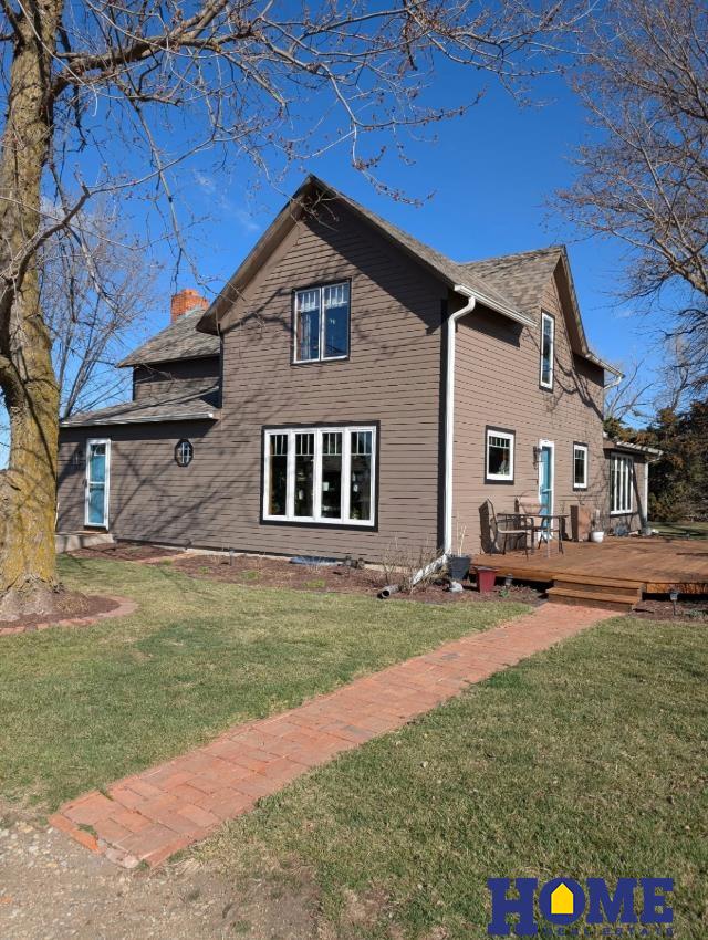 view of home's exterior featuring a chimney, a wooden deck, and a yard