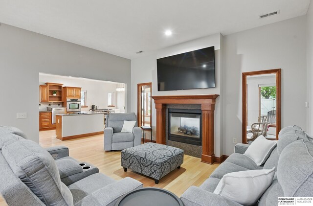 8153 Swallowtail St, Papillion, NE 68046 - living area with light wood finished floors, a multi sided fireplace, recessed lighting, and a chandelier
