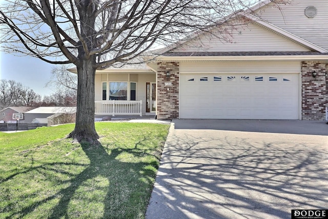 view of front of home with driveway, an attached garage, a front yard, brick siding, and a porch