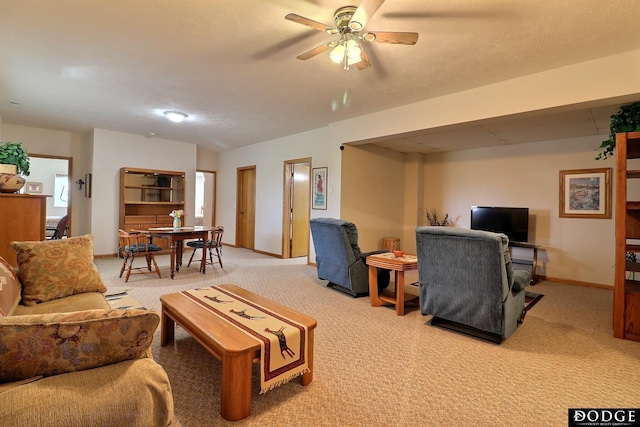living room with light carpet, baseboards, and a ceiling fan