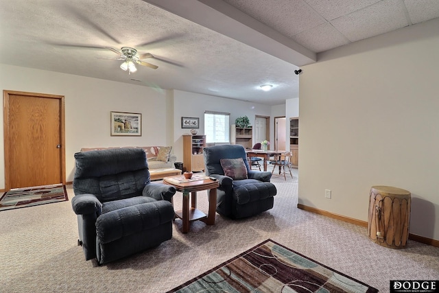 living area featuring ceiling fan, baseboards, a textured ceiling, and carpet floors