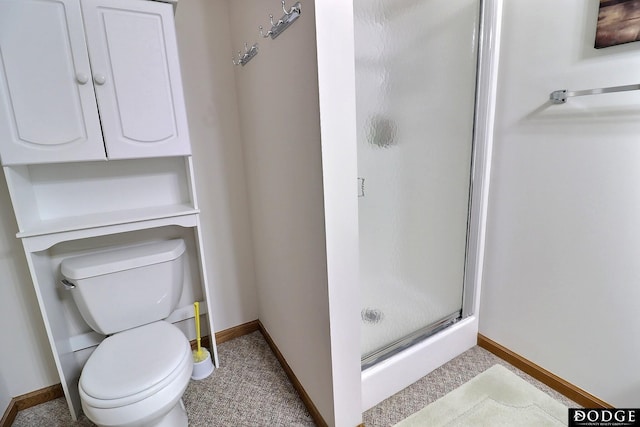 full bath featuring a shower stall, baseboards, and toilet