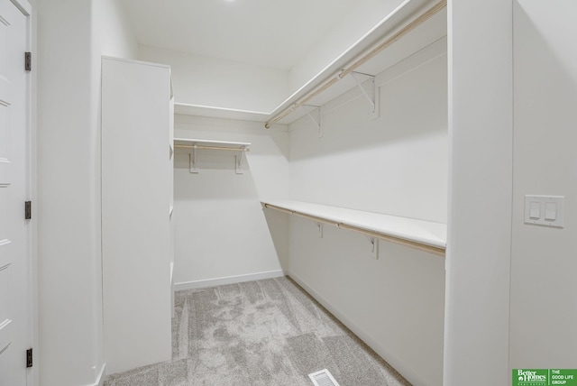walk in closet with light colored carpet and visible vents