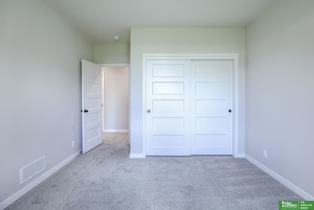 unfurnished bedroom featuring visible vents, baseboards, a closet, and carpet