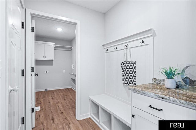mudroom with light wood finished floors and baseboards