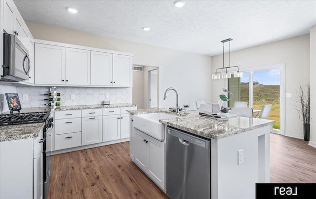 kitchen with tasteful backsplash, a sink, white cabinetry, and stainless steel appliances