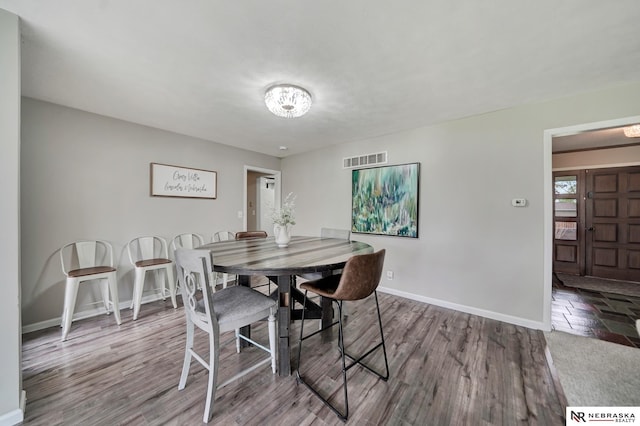 dining room featuring baseboards, wood finished floors, and visible vents