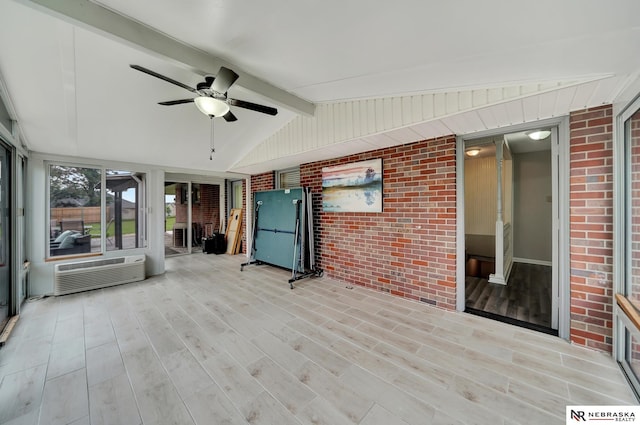 unfurnished sunroom featuring ceiling fan, a wall unit AC, and beam ceiling