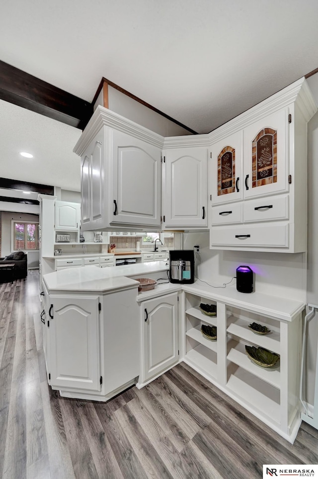 kitchen with light wood-style floors, light countertops, white cabinetry, and glass insert cabinets