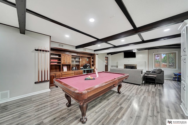 recreation room with baseboards, light wood-type flooring, beam ceiling, and visible vents