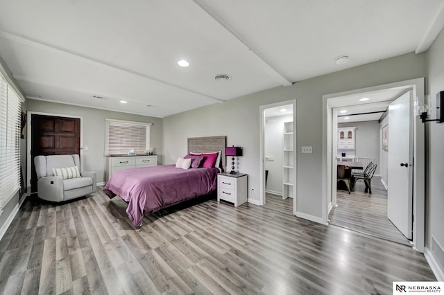 bedroom with baseboards, recessed lighting, wood finished floors, and visible vents