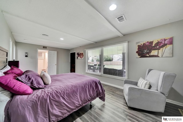 bedroom with baseboards, recessed lighting, wood finished floors, and visible vents
