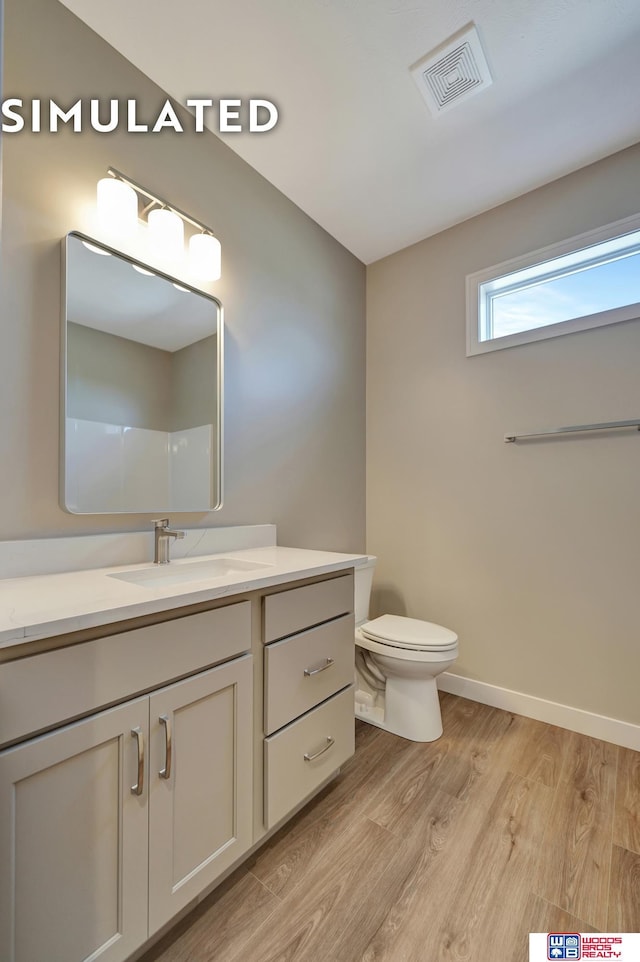 10551 Majestic Ln, Lincoln, NE 68527 - bathroom featuring vanity, visible vents, toilet, wood finished floors, and baseboards
