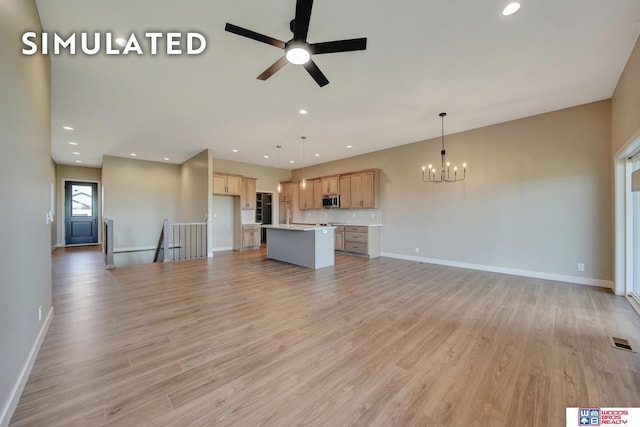 10551 Majestic Ln, Lincoln, NE 68527 - unfurnished living room featuring light wood-type flooring, ceiling fan with notable chandelier, visible vents, and recessed lighting