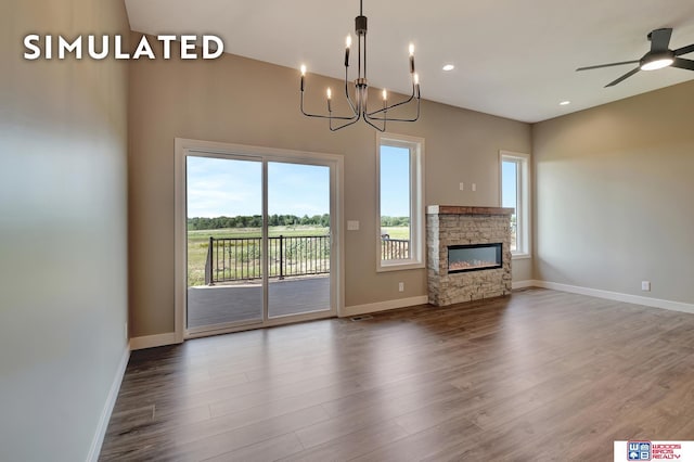 10551 Majestic Ln, Lincoln, NE 68527 - unfurnished living room with ceiling fan with notable chandelier, a stone fireplace, recessed lighting, wood finished floors, and baseboards