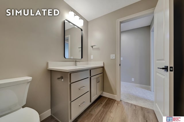 10551 Majestic Ln, Lincoln, NE 68527 - half bathroom featuring toilet, vanity, wood finished floors, and baseboards