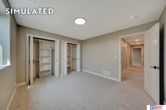 10551 Majestic Ln, Lincoln, NE 68527 - unfurnished bedroom with visible vents, multiple closets, carpet floors, and baseboards