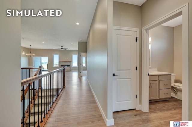 10551 Majestic Ln, Lincoln, NE 68527 - corridor with light wood-style flooring, baseboards, an upstairs landing, and recessed lighting
