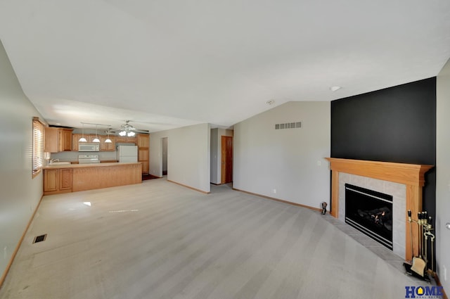 unfurnished living room with baseboards, a fireplace, lofted ceiling, and visible vents