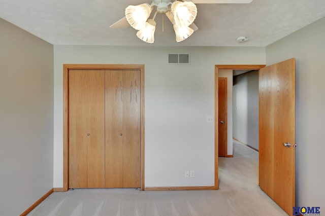 unfurnished bedroom featuring visible vents, baseboards, a closet, and light carpet