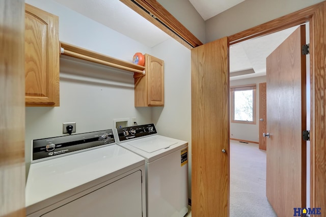 laundry area with separate washer and dryer, light colored carpet, and cabinet space
