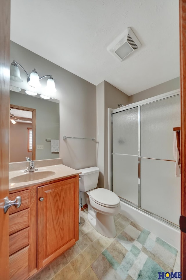 bathroom featuring a shower stall, vanity, visible vents, and toilet