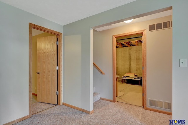 hallway featuring visible vents, stairway, and carpet