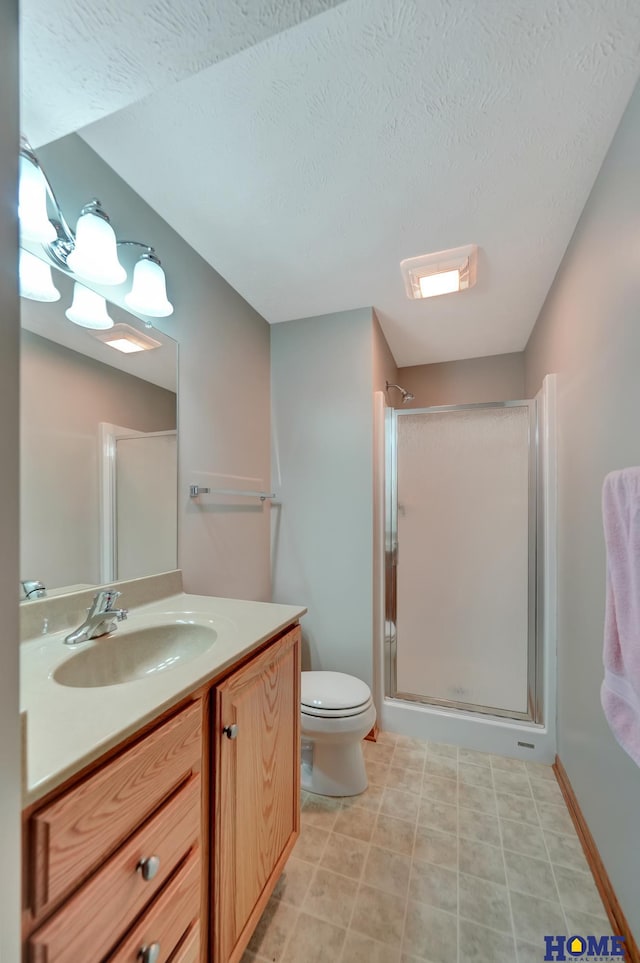 full bath featuring toilet, a textured ceiling, a stall shower, and vanity