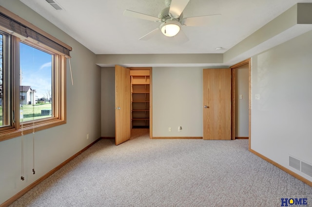 unfurnished bedroom with visible vents, baseboards, a ceiling fan, and carpet floors