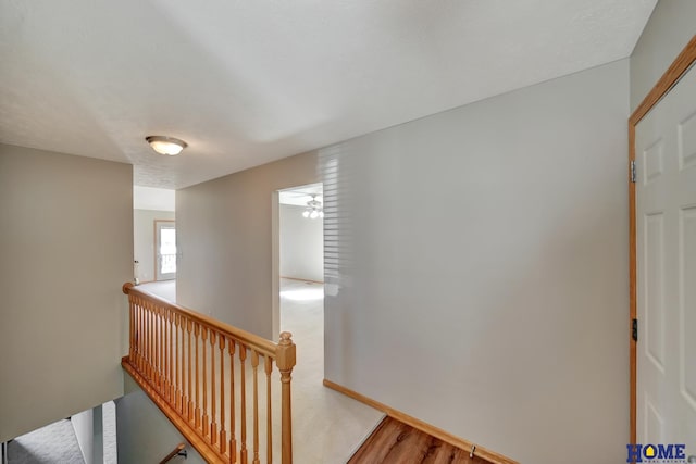 interior space with wood finished floors, baseboards, and an upstairs landing