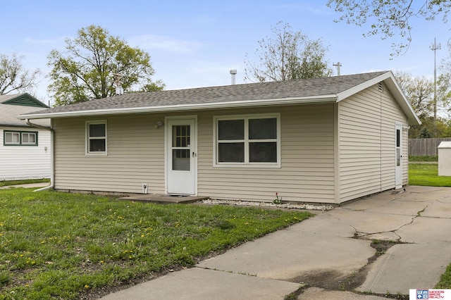 view of front of property with roof with shingles and a front yard