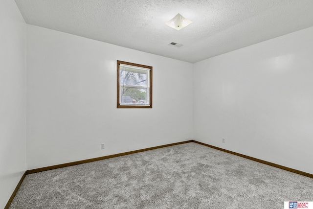 carpeted spare room featuring a textured ceiling, baseboards, and visible vents