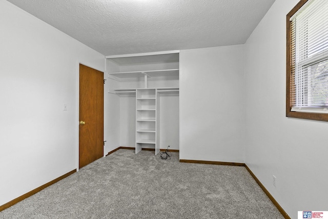 unfurnished bedroom with baseboards, carpet, a closet, and a textured ceiling