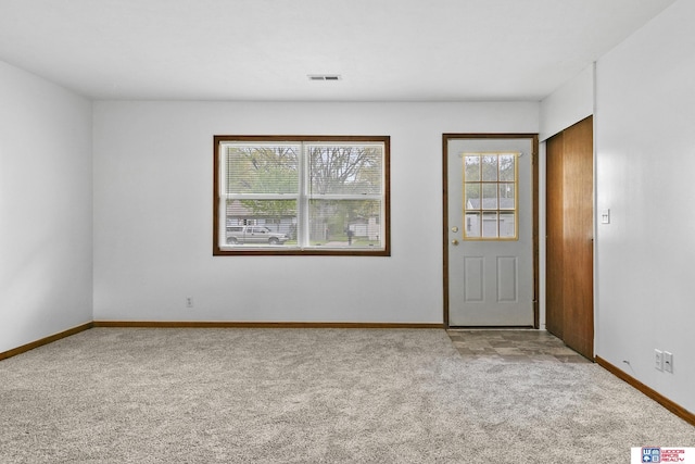 carpeted empty room featuring visible vents and baseboards