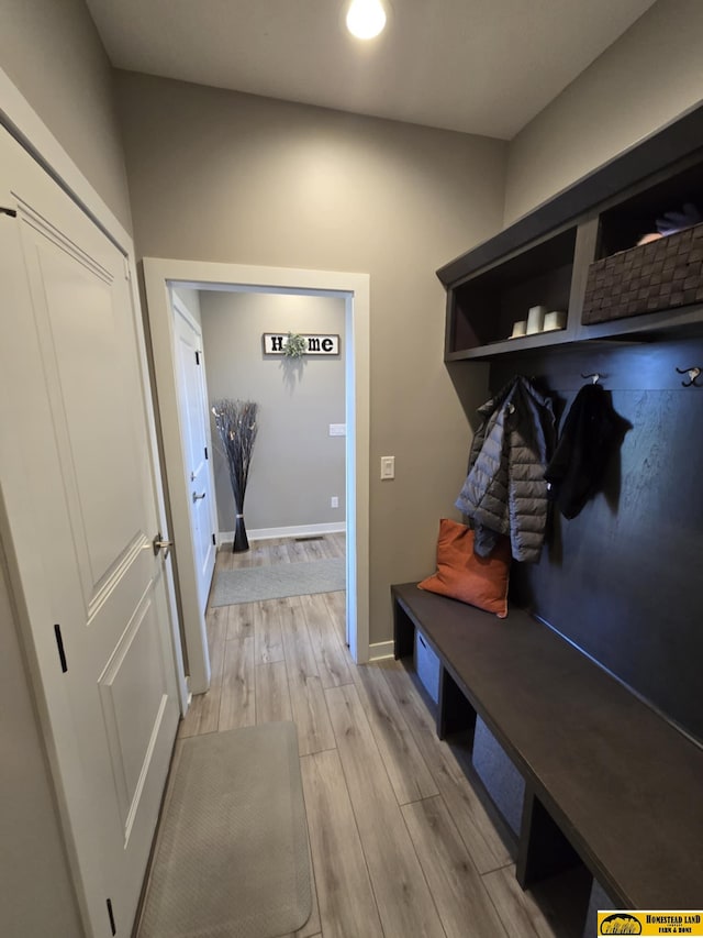 mudroom with light wood finished floors and baseboards