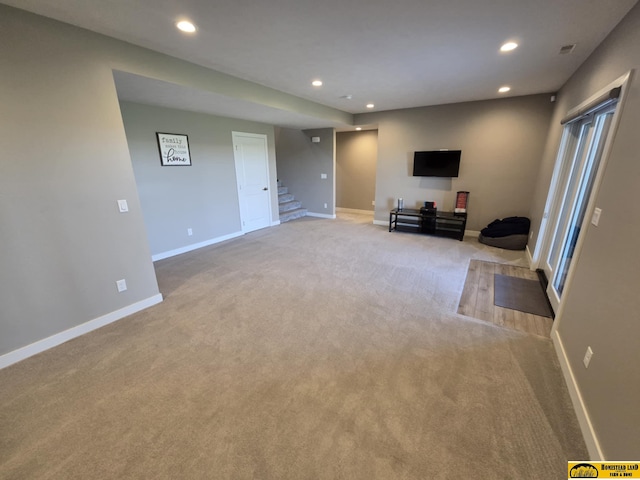 unfurnished living room featuring baseboards, stairs, and recessed lighting