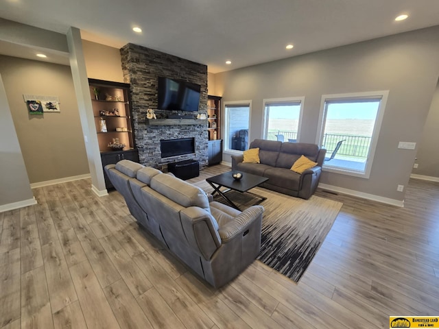 living room featuring baseboards, recessed lighting, wood finished floors, and a fireplace